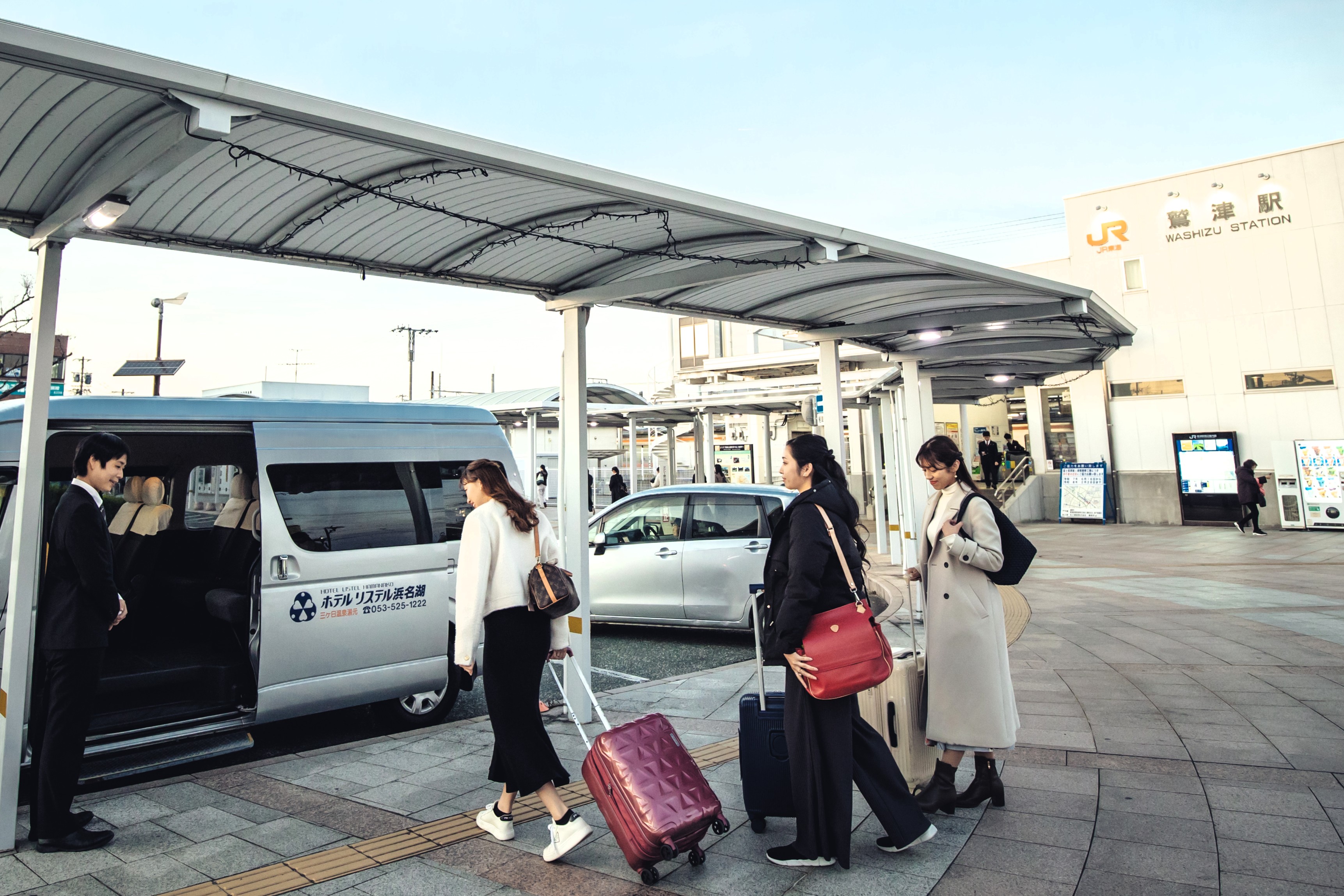 JR鷲津駅前でホテルリステル浜名湖の無料送迎車へ乗車する様子